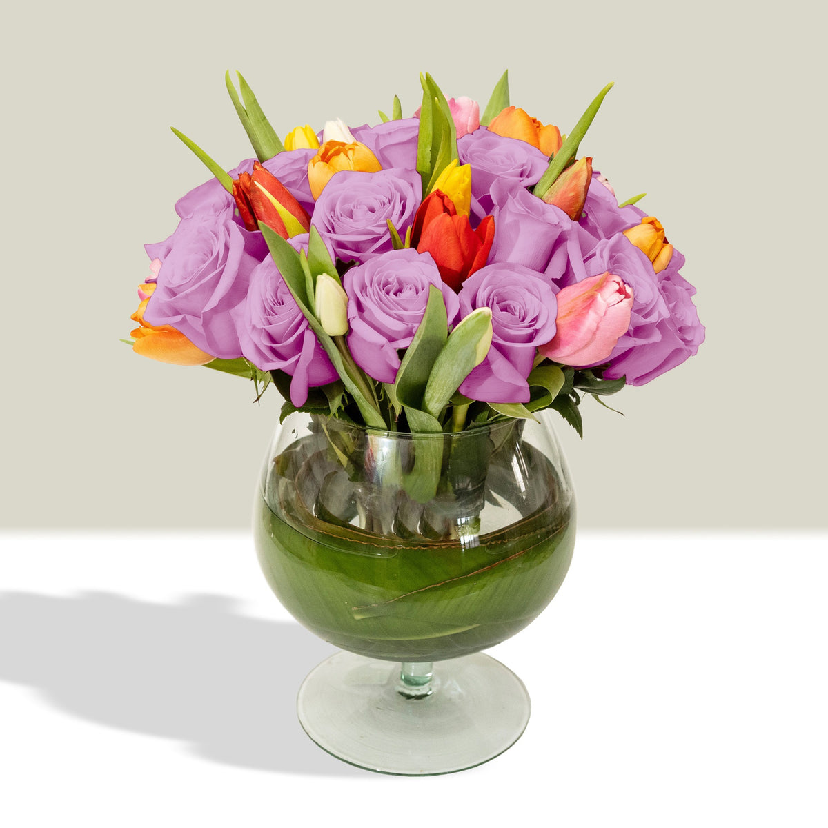Arreglo con 20 rosas y 20 tulipanes variados en florero copón, rosas lila
