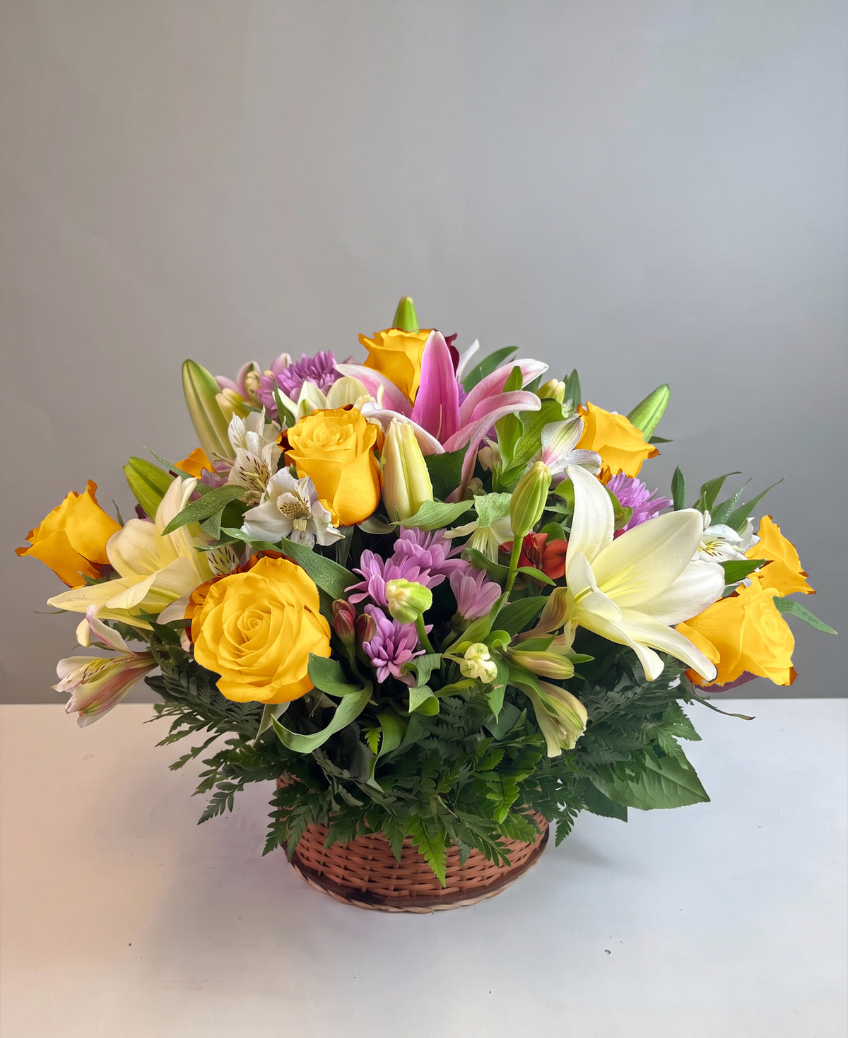 Canasta con 12 rosas, lilium y flores variadas, rosas amarillas