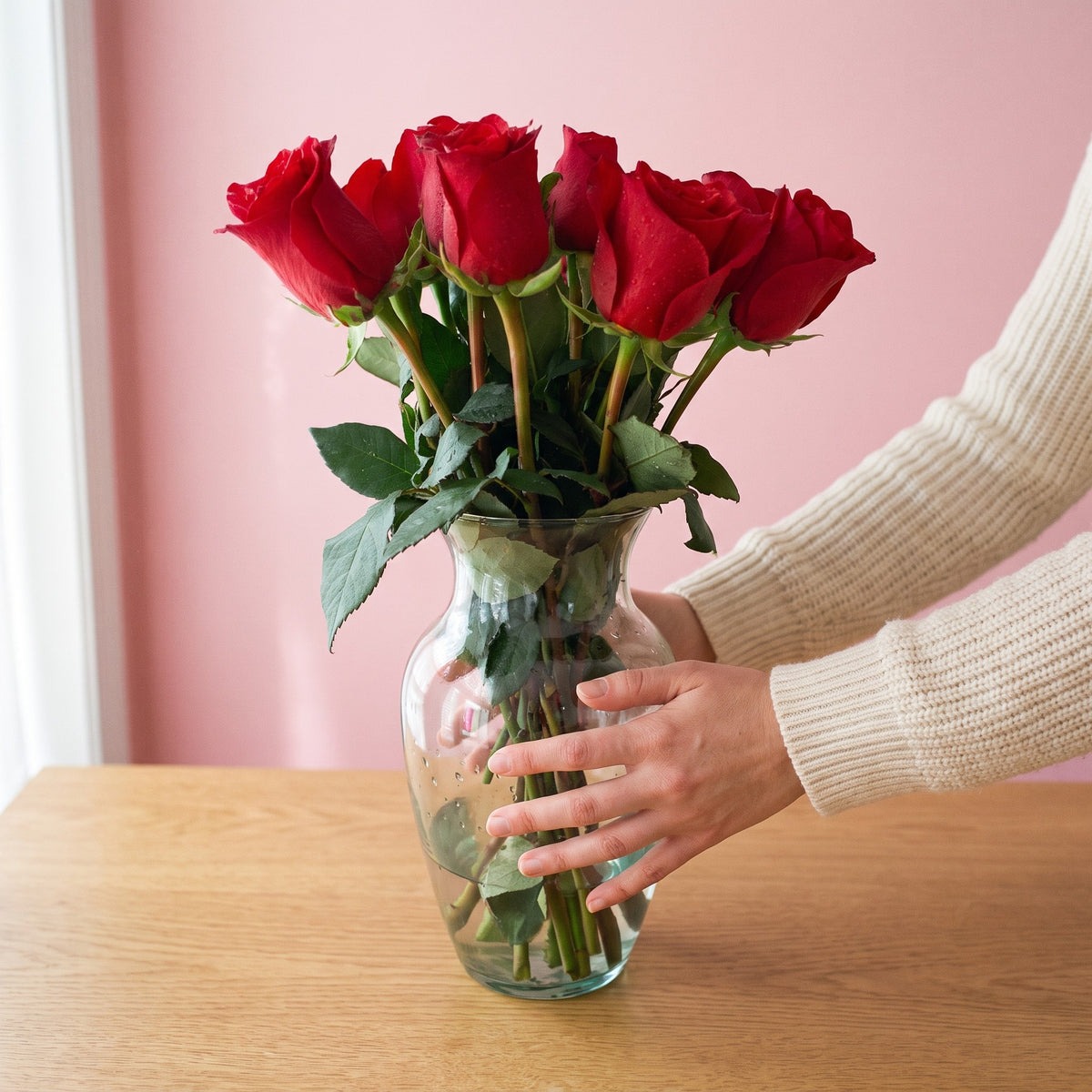 Arreglo con 12 rosas en florero Samaritano sobre la mesa