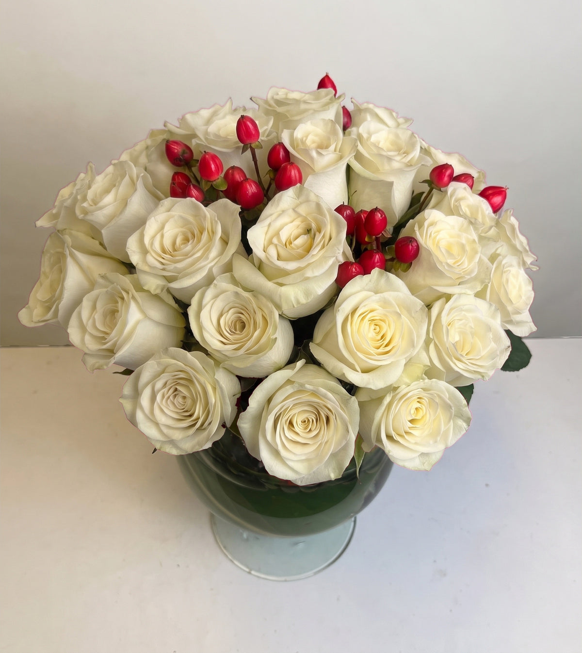 Arreglo con 30 rosas e hiperycum en florero copón, rosas blancas
