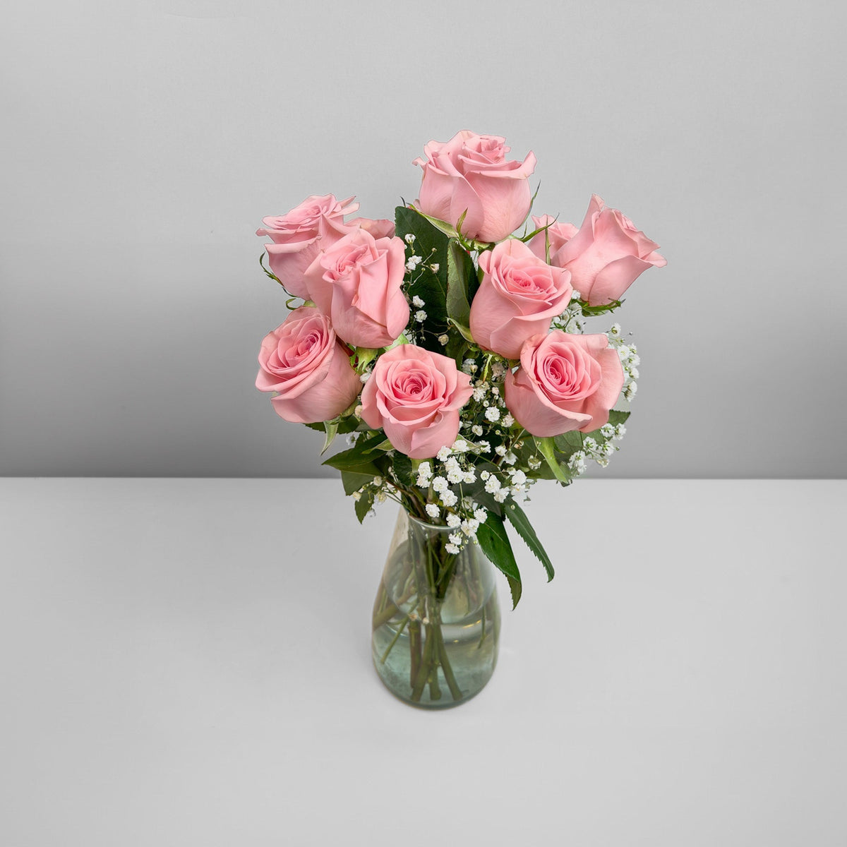 Arreglo con 12 rosas y gypsophila en florero modelo gélida, rosas rosadas