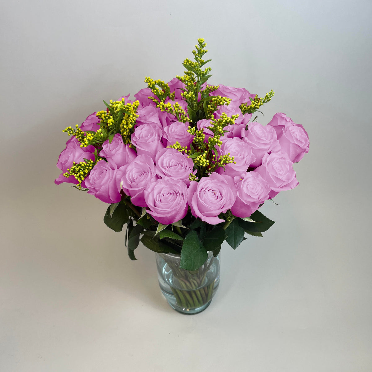 Arreglo con 30 rosas y follaje en base candelabro, rosas lila