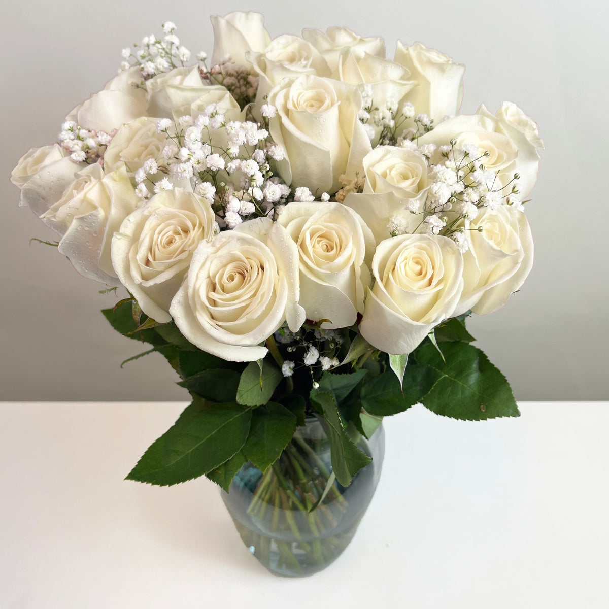 Arreglo con 21 rosas y gypsophila en florero samaritano, rosas blancas