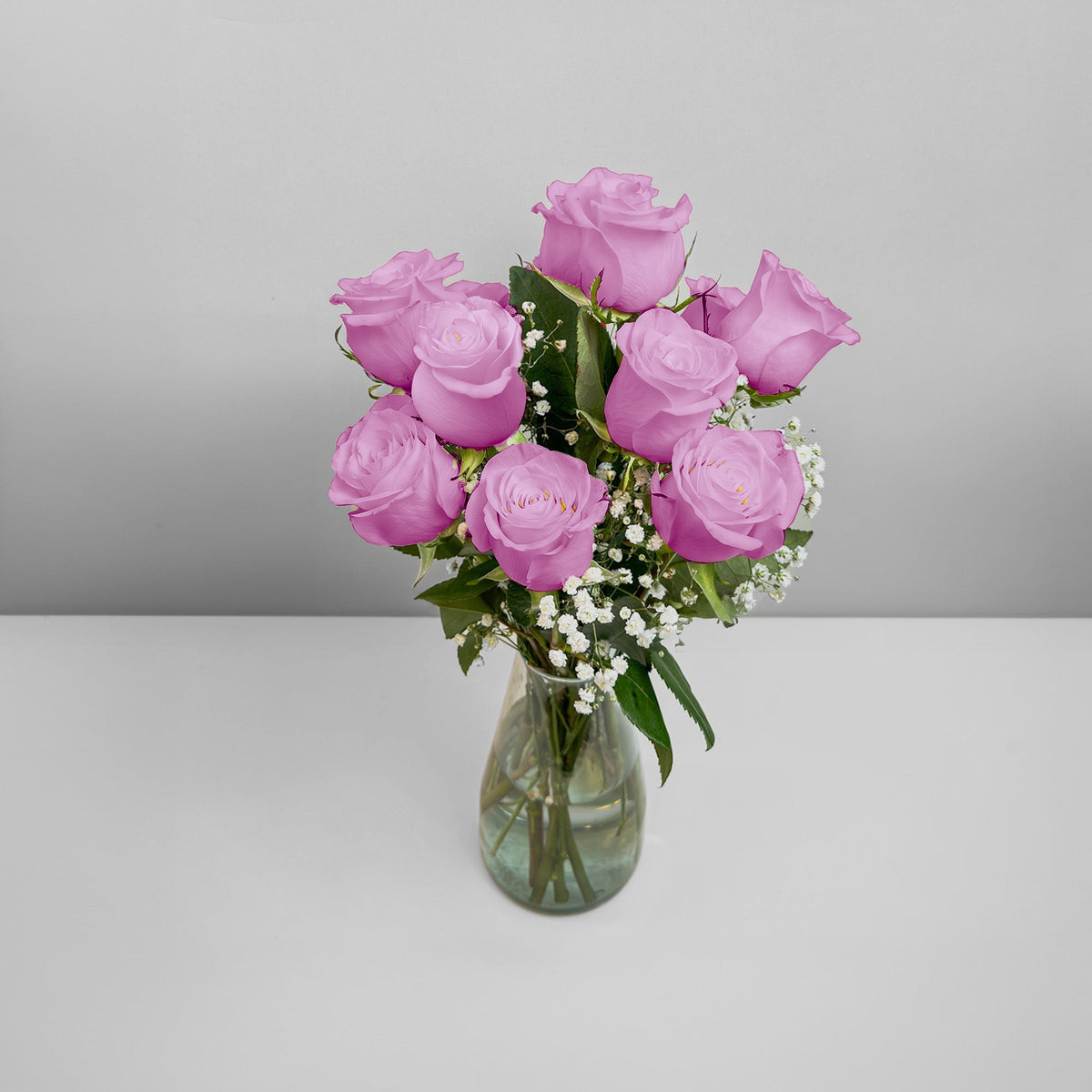 Arreglo con 12 rosas y gypsophila en florero modelo gélida, rosas lila