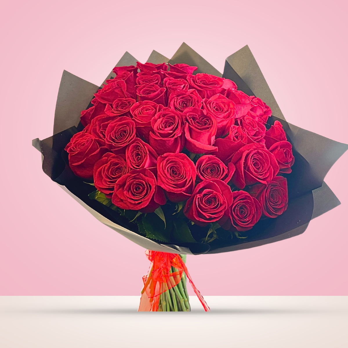 Ramo con 50 rosas rojas en papel negro, vista frontal