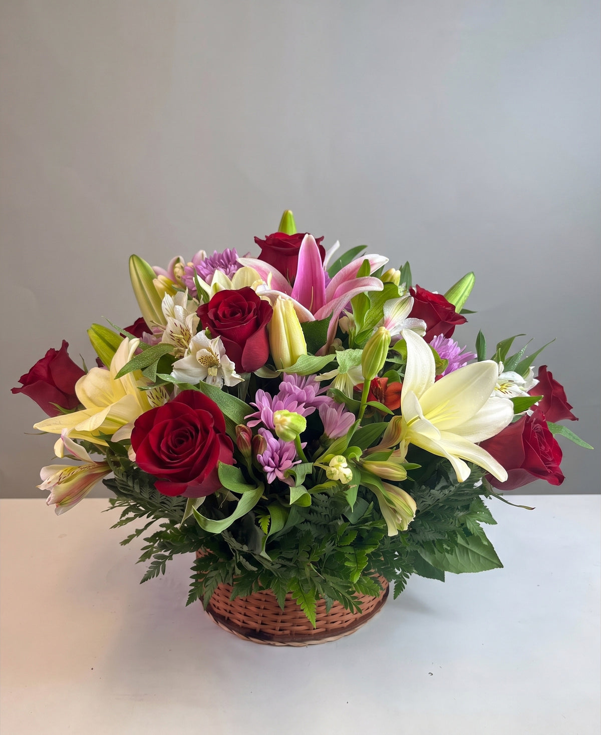 Canasta con 12 rosas, lilium y flores variadas, rosas rojas