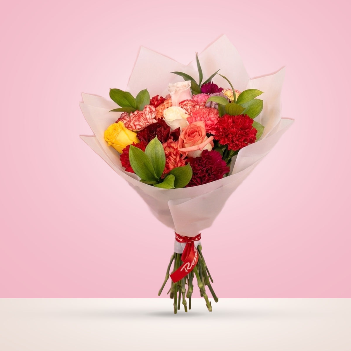 Ramo 15 claveles surtidos, 5 rosas y ruscus en papel coreano