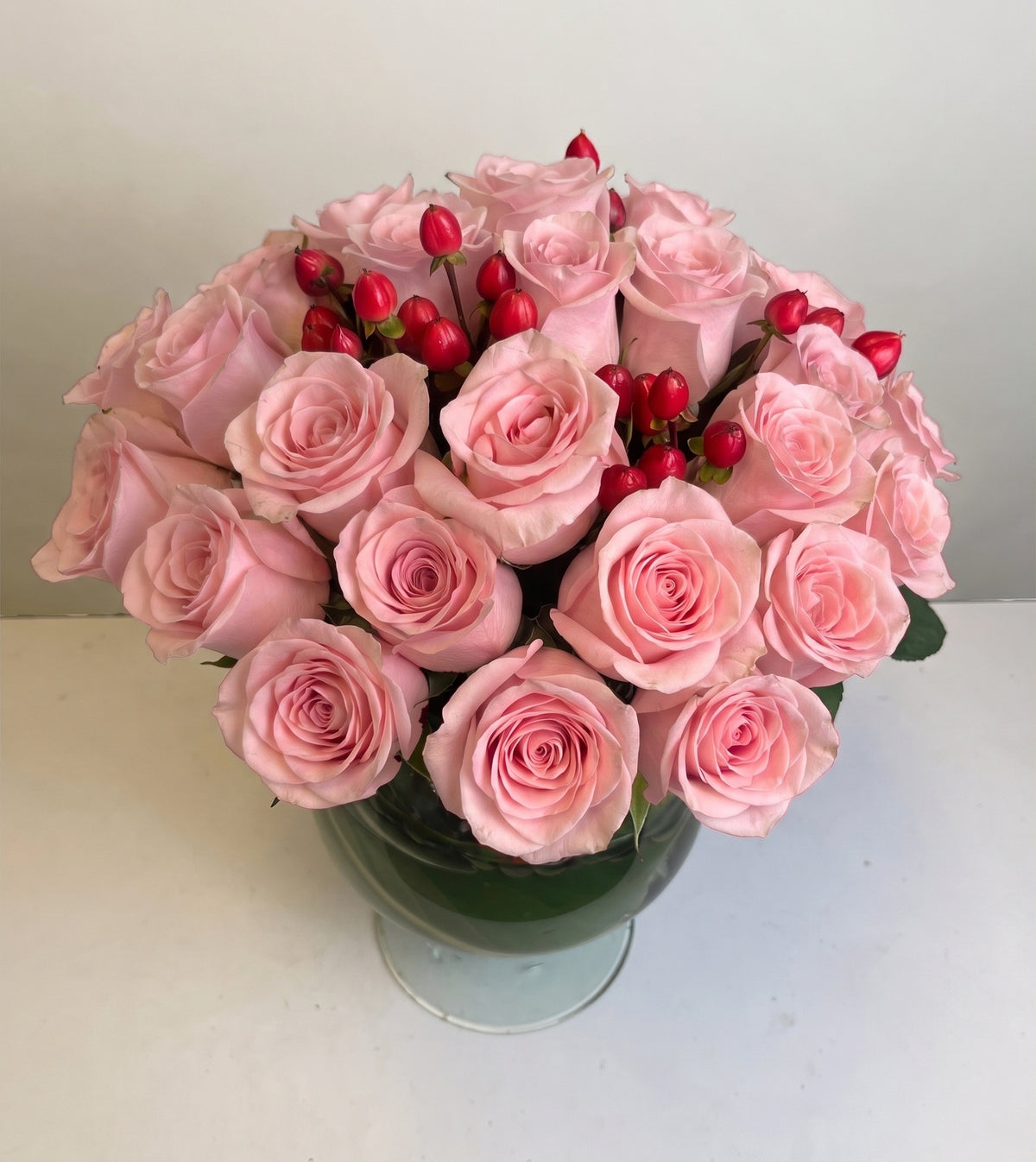 Arreglo con 30 rosas e hiperycum en florero copón, rosas rosadas