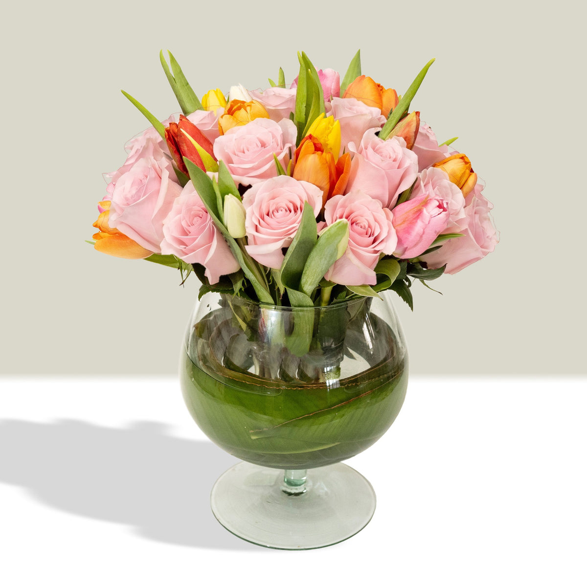 Arreglo con 20 rosas y 20 tulipanes variados en florero copón, rosas rosadas