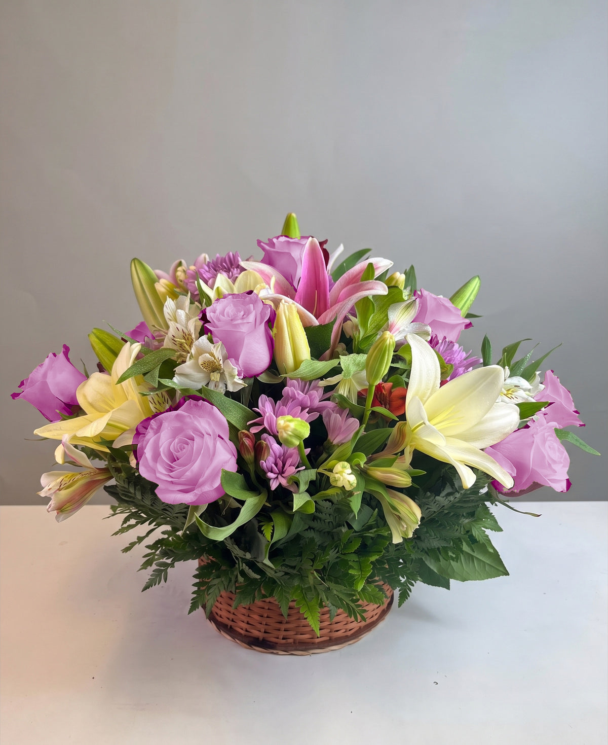 Canasta con 12 rosas, lilium y flores variadas, rosas lila