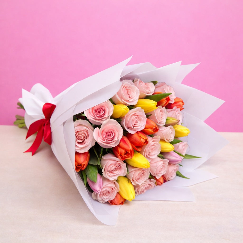 Ramo con 12 rosas rosadas y 10 tulipanes variados en papel blanco