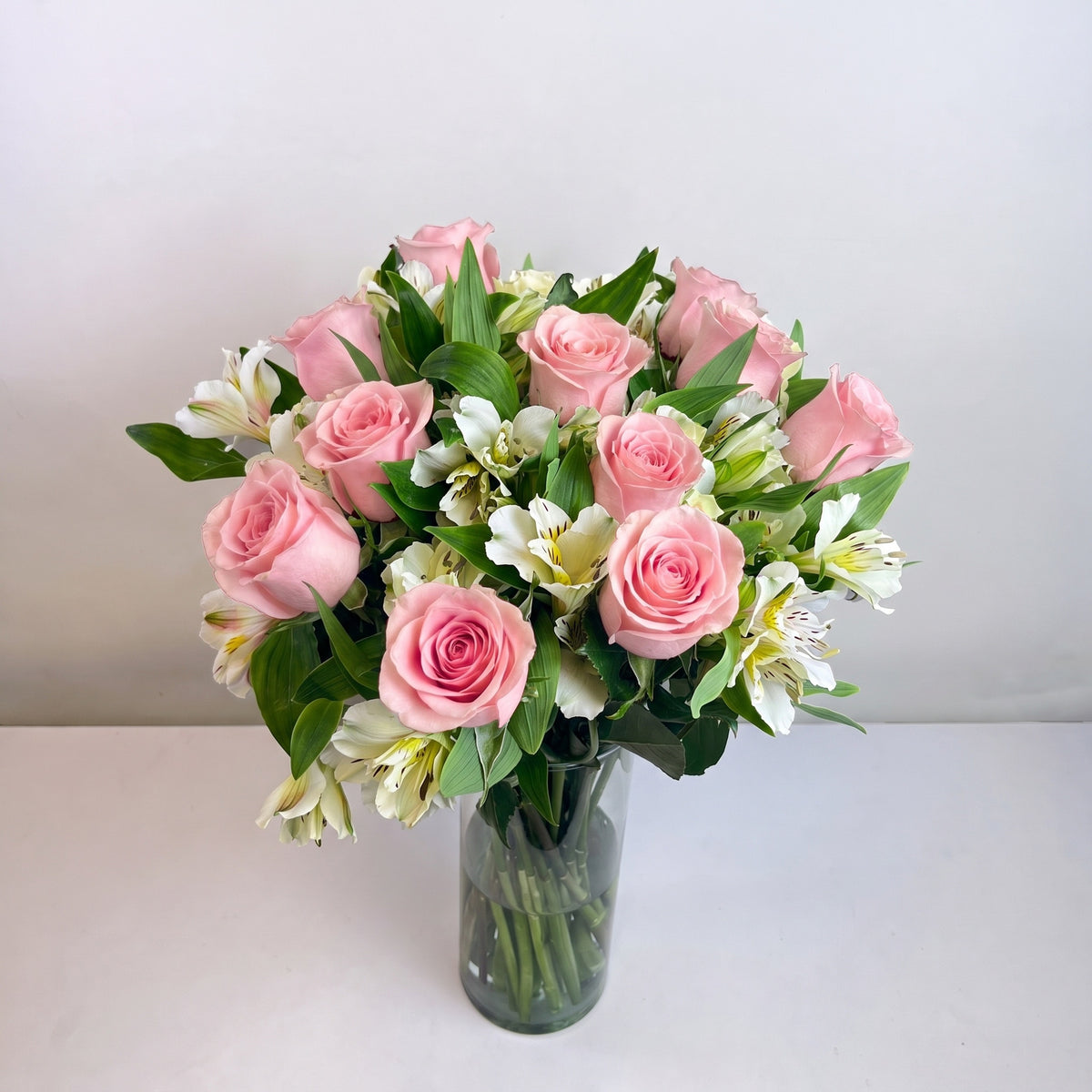 Arreglo con 12 rosas y astromelias en velón, rosas rosadas