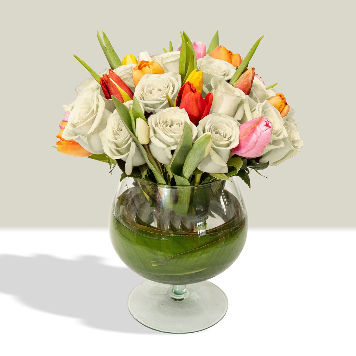 Arreglo con 20 rosas y 20 tulipanes variados en florero copón, rosas blancas