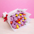 Ramo con 12 rosas lila y 10 tulipanes variados en papel blanco