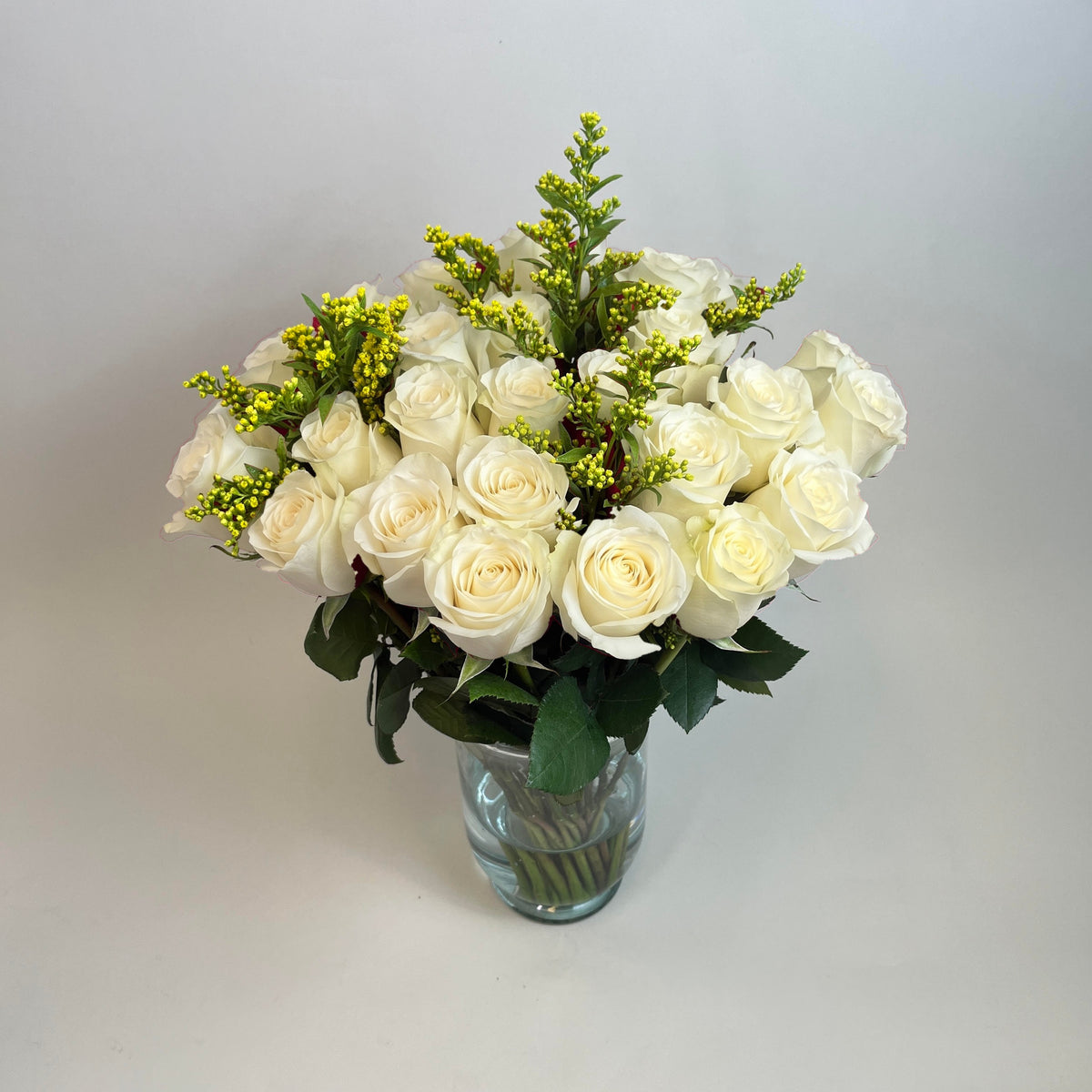 Arreglo con 30 rosas y follaje en base candelabro, rosas blancas