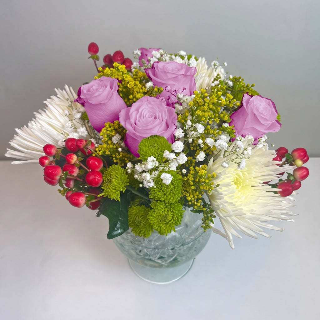 Arreglo con 5 rosas, spider y follaje en florero copón, rosas lila