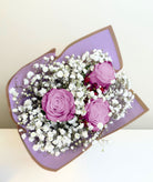 Ramo de 3 rosas con gypsophila en papel morado, rosas lila