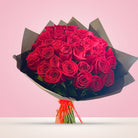 Ramo con 50 rosas rojas en papel negro, vista frontal